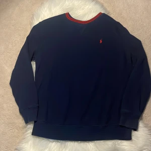 Mörkblå tröja från Polo Ralph Lauren - Mörkblå långärmad tröja från Polo Ralph Lauren. Skön och klassisk modell i bomull, perfekt för lager-på-lager under höst och vinter. Finns täcken på användning -skick:6-7/10