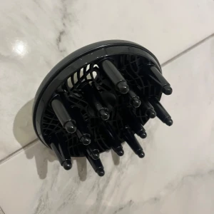 Hårtork Diffuser Munstycke - Svart diffuser-munstycke för hårtork, perfekt för att skapa volym och definiera lockar. Passar de flesta standard hårtorkar. Produkten är i mycket gott skick utan synligt slitage eller defekter. Enkel att montera och använda för ett professionellt resultat hemma.