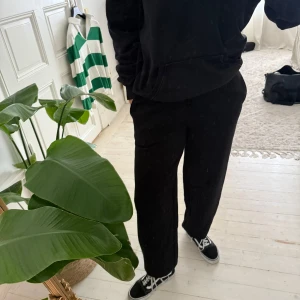 Svarta mjukisbyxor från BikBok - Svarta mjukisbyxor från BikBok i storlek S. Byxorna har resår i midjan med snörning och raka, lite vidare ben. Tillverkade i mjukt material som är perfekt för chill dagar. Klassisk och enkel look som funkar till sneakers. Aldrig använda 