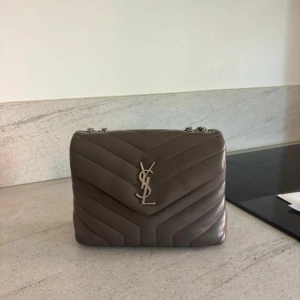 Yves Saint Laurent Lou Lou bag Medium - Säljer min Ysl Lou Lou bag i storlek M. Grå med silverdetaljer Använd men väl omhändertagen. Se bild för små ”defekter”  Kartong och äkthetsbevis medföljer självklart. Kan posta eller mötas upp i Stockholm.   mått: 30 cm x 20 cm x 10 cm (ungefär 11,8 tum x 7,9 tum x 3,9 tum)