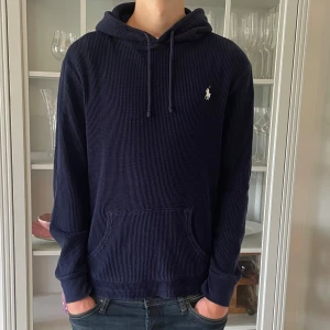Mörkblå stickad hoodie från Polo Ralph Lauren - S - Jag säljer den här riktigt snygga stickade hoodien från Polo Ralph Lauren i storlek S. Den är använd men fortfarande i väldigt bra skick utan defekter och skador. Tveka inte att höra av er!