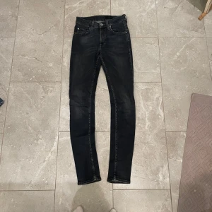 Svarta slim jeans från Tiger of Sweden - Snygga svarta jeans från Tiger of Sweden med slim passform och klassisk femficksdesign. Jeansen har en mörk tvätt och diskreta slitningar för en cool look. Tillverkade i stretchig denim som har passformen slim och bekvämt hela dagen.