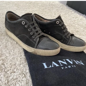 Svarta sneakers från Lanvin Paris - Snygga svarta sneakers från Lanvin Paris med ovandel i mocka och tåparti i blankt material. Skorna är i väldigt fint skick bara lite smutsiga just nu har inte haft ork att tvätta dom, men tvättas själv klart innan frakt. Dustbag hängs me på köpet, mer bilder går att få bara att skriva. Priset är inte hugget i stenen som sagt.😊