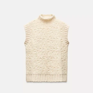 Stickad beige pullover med polokrage - Zara. Använd 1 gång. Säljer en stickad pullover i beige med polokrage och snyggt strukturmönster. Västen har ribbade kanter vid ärmhål och nederkant, vilket ger en cool och mysig vibe. Perfekt att styla över en skjorta eller t-shirt för extra lager.