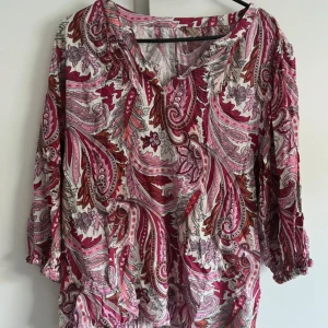 Mönstrad blus från Soya Concept - Färgstark blus från Soya Concept med paisleymönster i rosa, rött, vitt och orange. Blusen har v-ringning, trekvartsärmar med resår och en lös, flowy passform. 