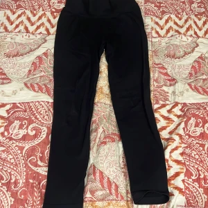 Svarta ribbade leggings från stadium  - Svarta leggings från Stadium i ribbat material med hög midja. De är tighta och stretchiga, perfekta för träning eller chill. Snygg passform och enkel design som funkar till det mesta. Storlek medium.