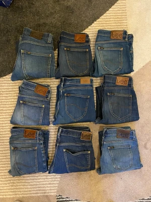 Blå jeans från Lee, olika tvättar - Säljer flera par klassiska blå jeans från Lee i olika tvättar och nyanser. Alla har den ikoniska Lee-lappen bak på linningen och raka eller lätt smala ben. Perfekta för dig som gillar tidlös denimstil och vill ha flera alternativ i garderoben.