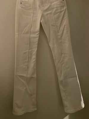 Vita bootcut jeans - Säljer ett par vita jeans i bootcut och med midwaist. Säljer då jag inte använder de längre 