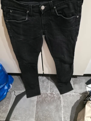 Svarta slim jeans från Lee - Snygga svarta jeans från Lee i slim fit-modell. Jeansen har klassisk femficksdesign, knappgylf och är tillverkade i bomull med lite elastan för skön stretch. Perfekta till alla outfits och riktigt bekväma.