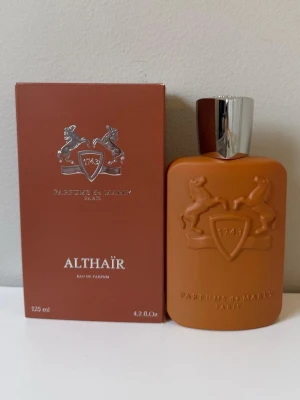 Parfums de Marly Althaïr EdP 125ml - Exklusiv parfym från Parfums de Marly, Althaïr Eau de Parfum i en snygg matt brun flaska med silverfärgat lock. Flaskan har ett elegant reliefmönster med två hästar och sköld. Kommer i matchande brun kartong. Volym: 125 ml.