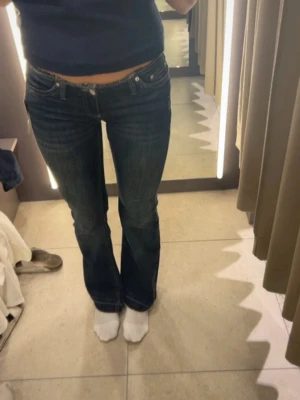 Nelly bootcut jeans - Snygga mörkblå bootcut jeans med låg midja och klassisk femficksdesign. Jeansen har en lätt utsvängd passform nedtill och kontrastsömmar. Perfekta för en avslappnad och trendig look.