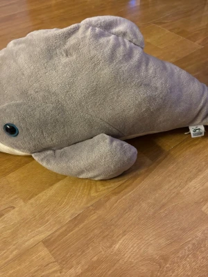 Grå mjukisdelfin från Wild Republic Kolmården - Säljer en supermjuk och gosig grå mjukisdelfin från Wild Republic. Delfinen har blå ögon, fenor på sidorna och är tillverkad i plyschmaterial. Perfekt som kramdjur eller dekoration i rummet.60 cm lång 20 cm bred utan fenorna på sidan.