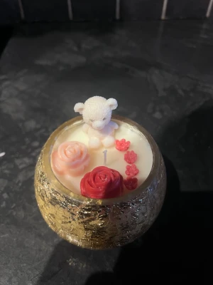 Alla hjärtans dag – Handgjort ljus från Glow Ritual - Gör Alla hjärtans dag extra speciell med ett vackert handgjort doftljus som sprider kärlek, värme och harmoni. Detta eleganta ljus i en gyllene glasbehållare är dekorerat med en söt nalle och fina rosdetaljer – en perfekt present till någon du tycker om. 🕯️🌹🐻 Passar perfekt som present till: ❤️ din partner ❤️ någon speciell ❤️ eller som en self-love present till dig själv Varje ljus är noggrant handgjort med kärlek och utvalda ingredienser för att skapa en mysig och romantisk atmosfär i ditt hem.