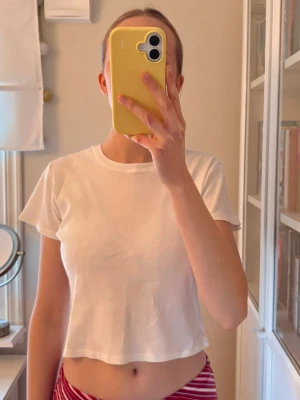 Vit croppad t-shirt i bomull - Enkel och fräsch vit croppad t-shirt med rund halsringning och korta ärmar. T-shirten har en avslappnad passform och är tillverkad i mjuk bomull, perfekt för en chill och stilren look. Använd en del men den är i väldigt bra skick, inga märkbara skavanker💕den är i one size men skulle säga att den passar XS. Bara att skriva om du undrar nåt. 