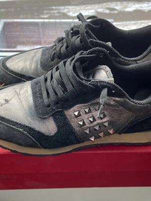 Svarta sneakers med nitar - Säljer ett par svarta valentino rockrunners, behöver få bort dem. Kommer med box samt kärlek❤️ Liten defekt på framsidan av sulan, kan sjölvklart visa flera bilder. Flytt på med prisförslag!