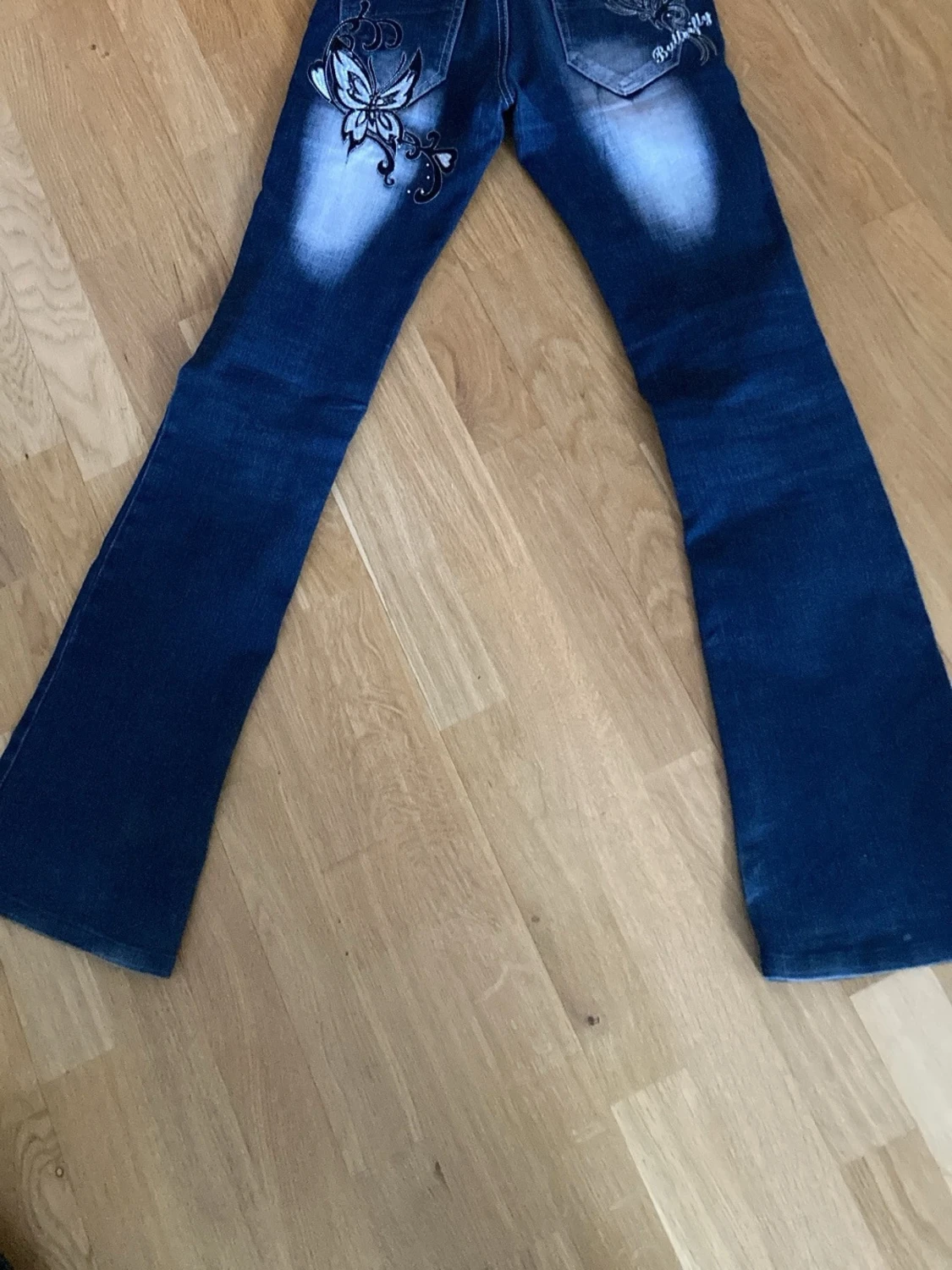 Blå bootcut jeans med fjärilsbrodyr