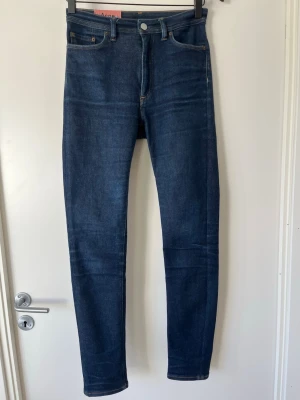 Mörkblå jeans från acne studios  - Snygga mörkblå jeans från acne studios endast prövade och använda någon gång. Jeansen har raka ben och är gjorda i stretchigt denim för en bekväm passform. Perfekta för dig som gillar stilrena och tidlösa jeans med modern siluett. Storlek är 27W 34L. Kom med bud, alla bud räknas jag kikar på alla oavsett hur stort. 
