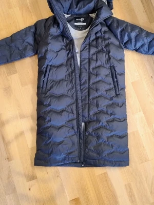 Helt ny Pelle P vinterkappa S - Helt ny med prislapp på  PELLE P W ZONDA JUGO COAT  Storlek Small   Höst- och vinterkappa, tillverkad i ett vindtätt yttermaterial med matt finish och 2-vägs dragkedja från YKK framtill. Kappan har bondad mönstring för jämn fördelning av vadderingen som är till 100% tillverkad av återvunna PET-flaskor. Kappan har ett kontrastfärgat foder. Zonda Jugo Coat har två dragkedjeförsedda sidfickor, en innerficka i mesh och elastiska band i ärmsluten. Kappan är normal i passformen, har Pelle P-print på h