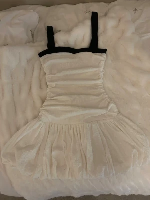 Vit kort klänning från ZARA - Supersöt vit kort klänning med svarta axelband och en typ av bubble underdel från ZARA, använd 1 gång, super fin till festliga tillfällen, skriv för fler bilder!💕