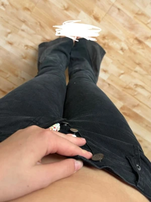 Svarta bootcut jeans med väldigt låg midja - Säljer ett par svarta bootcut jeans med lågmidja (väldigt låg) och klassisk femficksdesign. Jeansen har vida ben från knät och ner, samt dubbla knappar i linningen. Säljer pga att dom är för små för mig. Köpta secondhand 
