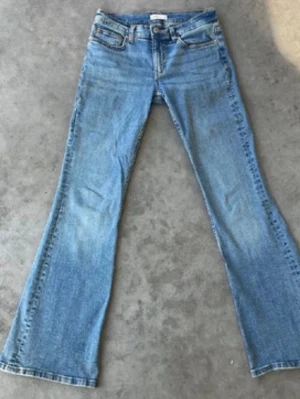 Blå bootcut jeans - Säljer ett par superfina blå jeans med bootcut passform. Jeansen har låg midja och är tillverkade i ett mjukt denimtyg som sitter jättebra!