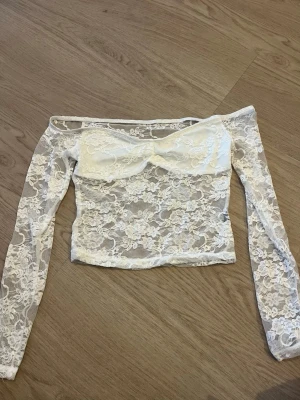 Vit spets offshoulder topp - Säljer en superfin vit offshoulder topp i spets med lång ärm. Storlek XS/S. 