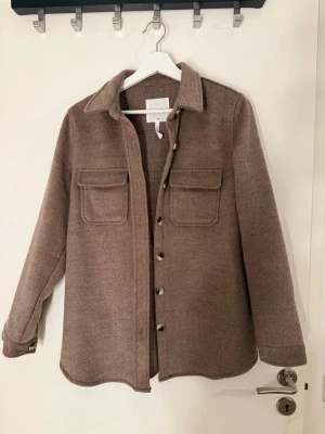 Brun kappa - Stilren brun kappa från märket Object. Kappan är helt ny och är aldrig använd. Utan prislapp 