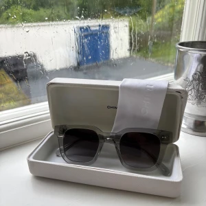 Grå Chimi solglasögon - Ett par snygga Chimi glasögon i ett superbra skick. Allt tillkommer förutom kvitto som har förvsunnit. Enda skavanken är en fläck på boxen som man kan se på sista bilden. Säljs för 490