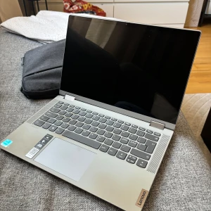 Lenovo IdeaPad Flex 5 14ITL05 - Lenovo IdeaPad Flex 5 14ITL05 i silver, 14" touchskärm, flexibel 2-i-1-design. Skärmen är i fint skick, mindre märken på locket, en skada på en av kanterna samt lite missfärgning vid tangentbordet. Den fungerar felfritt men säljer då den inte kommer till nån användning. Hade den till att studera körkortet. Levereras med laddare (ej original) och datorväska. Perfekt för studier eller arbete. Kostade runt 6-7 tusen ny när jag köpte den