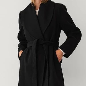 Svart kappa med bälte och sjalkrage - Stilren svart kappa med sjalkrage och knytskärp i midjan. Lång modell med raka ärmar och fickor i sidorna. Lite nopprig. Perfekt för dig som vill ha en klassisk och snygg look under höst och vinter. Materialet är mjukt och känns lyxigt. Från Gina. Nypris 1299kr 