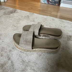 Beige sandaler med platåsula - Snygga beige sandaler med bred rem i mocka och plattformsula i flätad jute. 