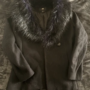 Svart kappa med fuskpäls från H&M - Snygg svart päls kappa från H&M, storlek 38 