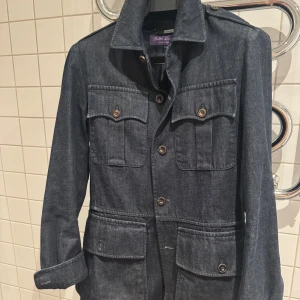 Ralph Lauren Purple Label  Selvedge Denim Overshirt - Här har vi något riktigt unikt. En jeansjacka i råselvedge från RL Purple Label. Ett material som ger väldigt fina fades över tid. Halvfodrad med fyra stora fickor, samt ett skärp som följer med. Enbart använd ett fåtal gånger, men inget som syns. Nypris ligger på cirka 28-30K.