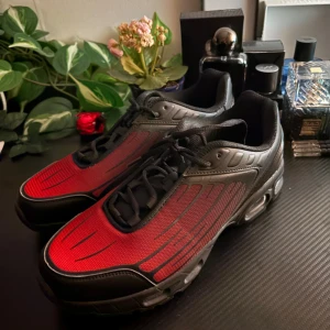 Svarta och röda sneakers med snörning - Säljer ett par riktigt snygga sneakers i svart och rött med coola detaljer och sportig vibe. Skorna har snörning, rund tå och platt sula. Ovandelen är i textil och syntet med svarta och röda paneler som ger en modern look. Perfekta för dig som gillar streetstyle. Priset kan kollas !!!!!