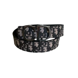 Svart mönstrat bälte från Dior - Snyggt svart bälte från Dior med ikoniskt mönster och silverfärgat CD-spänne. Bältet har en klassisk form och är perfekt för att lyfta vilken outfit som helst med en lyxig touch. Materialet är skinn och mönstret ger en exklusiv känsla.