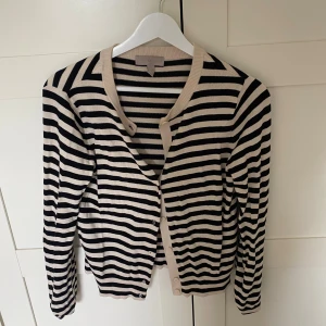 Randig kofta från H&M i beige och svart - Snygg randig kofta från H&M i beige och svart. Långärmad och i mjukt, tunt material som passar perfekt till lager-på-lager. Sällan använd 