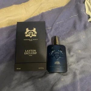 Layton Exclusif Parfym 125ml - Lyxig parfym från Parfums de Marly, Layton Exclusif. Flaskan rymmer 125 ml. Ingredienser: alkohol denat., aqua, limonene, linalool, benzyl alcohol, coumarin, citronellol, BHT, citral, geraniol. Tillverkad i Frankrike. Atumizern har en liten ändring då den råkade gå sönder men den är utbytt nu!