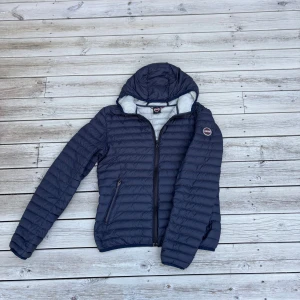 Mörkblå Colmar dunjacka med huva - Snygg mörkblå dunjacka från Colmar med huva. Perfekt för kyliga dagar och enkel att matcha med din stil. Storleken är 16 (172). Skick på jackan är 9/10 bara använd några gånger. Det är bara att skriva om ni har några frågor 🙌.