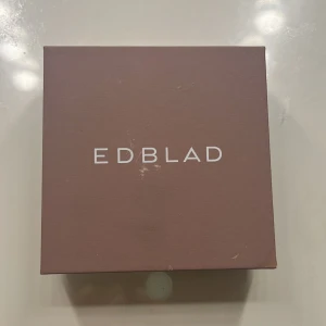 Silvriga örhängen från Edblad - Snygga silvriga örhängen från Edblad med minimalistisk design. Örhängena har små ringar med hängande konformade detaljer som ger en cool och stilren look. Perfekta för dig som gillar enkla men ändå unika smycken. Aldrig används 