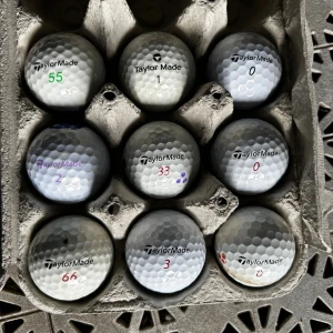 TaylorMade Golfbollar - Sats med 9 TaylorMade Rocketballz golfbollar i blandade nummer. Bollarna är i gott begagnat skick med mindre tecken på användning. Perfekta för träning eller spel. Inga större skador synliga, vissa bollar har mindre märken eller färgmarkeringar.