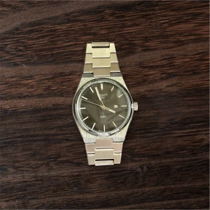 Tissot PRX silverfärgad klocka - Säljer min Tissot PRX som nyligen blivit behandlad och servad. Klockan är i fint skick – både boett och länk har fått tillbaka sin glans och urverket går som det ska.  En riktigt mångsidig klocka som passar både till vardag och finare tillfällen. Slimmad profil, snygg design och väldigt bekväm på handleden.  Perfekt för dig som vill ha en klassisk PRX i fräscht skick, redo att användas många år framöver. kan gå ner en bra bit för en snabb affär 