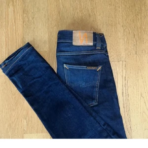Mörkblå jeans från Nudie Jeans - Snygga mörkblå jeans från Nudie Jeans med klassisk femficksdesign och kontrastsömmar. Är försmå så vill gärna få bort, kan gå ner i pris vid snabb affär!