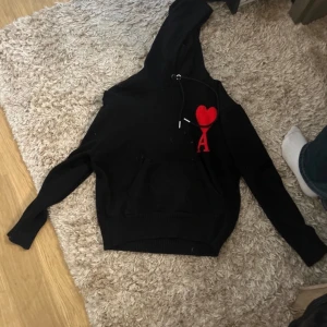 Svart stickad hoodie från Ami Paris - Svart stickad hoodie från Ami Paris. Tröjan har huva  