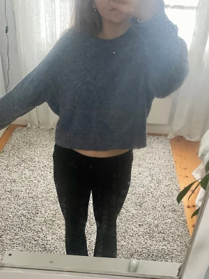Blå stickad tröja - Mysig blå, croppad, stickad tröja med rund hals och långa ärmar. Perfekt för lager på lager, ex. med ett linne under, eller bara som den är. Säljer då den inte kommer till användning längre.