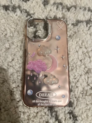 Rosa DEEAM mobilskal med glittermotiv - Snyggt mobilskal i rosa med skimrande yta och 3D-motiv av moln, måne, hjärta och stjärnor. Texten 'All the thoughts are stars and all the stars are you' står längst ner. Skalets kanter är transparenta och det har en förstärkt ram runt kameran.