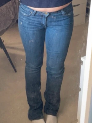 Blå bootcut jeans från Lee - Säljer ett par klassiska blå bootcut jeans från Lee. Jeansen har normal passform, snyggt läderpatch med Lee-logga bak i midjan. Storlek 38 men passar nog storleken 36 med.