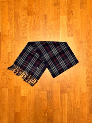 Mörkblå Burberry halsduk - Säljer är mörkblå halsduk från Burberry. Halsduken är gjord i 100% kashmir och är i fint skick. Var inte rädd för några frågor. Pris diskuteras inte!