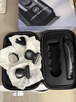 Björn Axén Multi Pro Groomer Oanvänd - Multiverktyg för grooming från Björn Axén Tools. Helt ny och oanvänd. Setet innehåller en svart och silverfärgad trimmer med flera utbytbara huvuden och tillbehör, allt i ett smidigt svart fodral. Perfekt för hår, skägg och detaljtrimning.