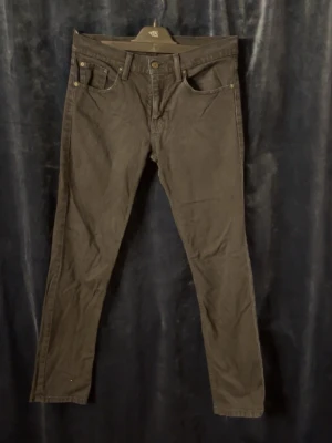 Svarta Levi's 511 jeans  - Snygga svarta Levi's 511 jeans med klassisk femficksdesign och knappgylf. Jeansen har raka ben. Tillverkade i mjukt bomullsmaterial med en diskret Levi's-lapp bak i midjan och röd etikett på bakfickan. Skriv för frågor (Storlek 30/32) 