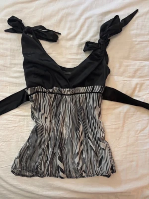 Zebramönstrad topp från Comely - Snygg zebramönstrad topp från Comely med svarta knytband på axlarna  men man kan även knyta den back vid ryggen för att få en ”snatched” figur! Det finns även en dragkedja på sidan av tröja. Skulle säga att storleken på tröjan är mellan S och M. Skriv gärna privat om ni undrar över något 💕🫶